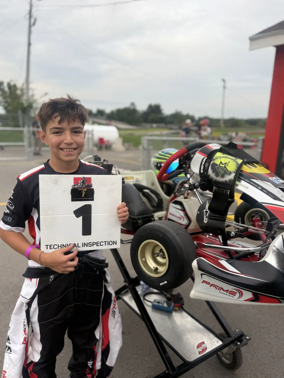 Damian smiling in the paddock next to his kart